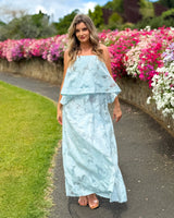 House of Holabox icy blue sheer floral midi dress with tiered silhouette, straight neckline, and adjustable straps.