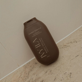 House of Holabox Ivy Ila Japanese Honeysuckle body polish in a brown 200g squeeze tube on a neutral surface.