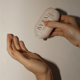 House of Holabox Ivy Ila coconut and sandalwood hand cream being squeezed into a palm for application