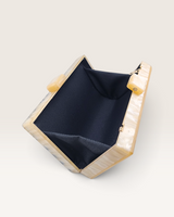 House of Holabox Izoa Krista clutch in cream marble acrylic with an open interior and gold hardware details.