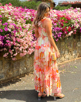 House of Holabox Katelyn maxi dress in pink, coral, and orange floral print with frill sleeves and a tiered skirt.