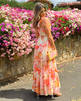 House of Holabox Katelyn floral maxi dress with frill sleeves, tiered skirt, and pink, coral, and orange print.