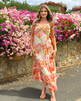 Model wearing a House of Holabox Katelyn floral maxi dress with frill sleeves and tiered skirt in pink and orange