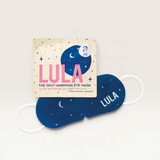 House of Holabox Lula self-warming eye mask in navy blue with star print next to its cream-coloured packaging