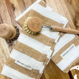 House of Holabox Mama and Tochter French linen tea towel with wide toffee stripes and wooden kitchen brushes