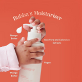 House of Holabox Mamave Bubba’s Moisturiser in a pump bottle held by a baby's hand against a vibrant orange background.