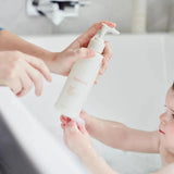 House of Holabox Mamave Bubba’s Wash being dispensed into a parent's hand during a baby's bath time.