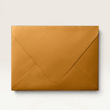 House of Holabox matte antique gold envelope for a greeting card, shown against a matching warm latte background.