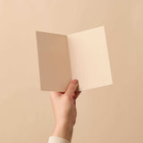House of Holabox Happy New Home signature foil greeting card held open against a neutral beige background