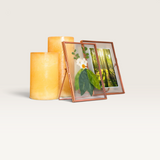 House of Holabox Nicola Spring metallic photo frames displaying pressed flowers and a forest photo next to candles.