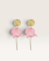 House of Holabox Olivia dangle earrings featuring matte gold discs and light pink layered flower petals on gold posts.