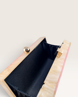 House of Holabox Izoa Brooke pink marble acrylic clutch with open interior, black lining, and gold hardware clasp.