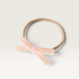 House of Holabox Snuggle Hunny baby headband featuring a soft pink velvet petite bow on a stretch nylon elastic band