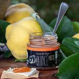 House of Holabox Port Willunga Fine Foods quince paste in a glass jar with a spoon, served on a cracker with cheese.