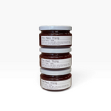 House of Holabox The Peel Thing quince paste in three stacked glass jars with white lids on a white background.