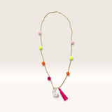 House of Holabox rabbit pom pom necklace with a white rabbit charm, neon pink tassel, and colorful pom pom beads.