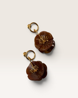 House of Holabox Second Nature earrings featuring brown sculptural resin flowers on polished gold hoops.