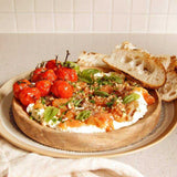 House of Holabox Ripe Tomato Relish served on creamy cheese with roasted tomatoes, fresh basil, and crusty bread.