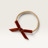 House of Holabox Snuggle Hunny baby headband featuring a rust brown velvet petite bow on a soft stretch nylon band.