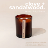 House of Holabox saide. large amber glass soy candle with a wood wick and clove and sandalwood label