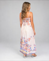 House of Holabox Sara Spring Maxi Dress in a yellow floral print with ruching and back pockets, back view.