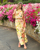 House of Holabox Sheree high neck sleeveless maxi dress with painterly floral print in blush, peach, and green tones.