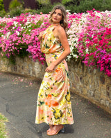 House of Holabox Sheree high neck sleeveless maxi dress with painterly floral print in blush, peach, and green tones.