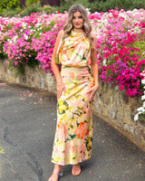 House of Holabox Sheree high neck sleeveless maxi dress with a painterly floral print in blush, peach, and green.