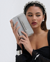 House of Holabox Marie silver glomesh party crossbody bag held by a model wearing a matching silver headband.