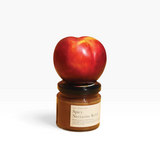 House of Holabox Women’s Work spicy nectarine relish jar topped with a fresh nectarine on a yellow background