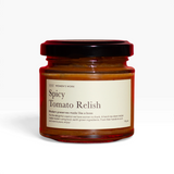 House of Holabox Women’s Work spicy tomato relish in a 115g glass jar with a black lid against a red background.