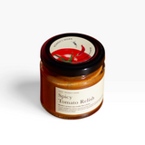House of Holabox Women’s Work spicy tomato relish in a 115g glass jar with a black lid on an orange background.