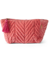 House of Holabox strawberry pink velvet toiletry bag with quilted chevron pattern, zip closure, and decorative tassel.