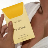 House of Holabox Stray Willow Golden Glow facial mask in a yellow compostable packet held by a person in a robe.