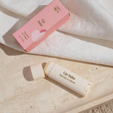House of Holabox Stray Willow Peaches and Cream lip balm in a pink box and cream-coloured tube on a stone surface.