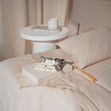 House of Holabox Stray Willow Wild Fields skincare duo set resting on a book in a neutral-toned bedroom setting.