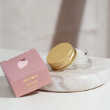 House of Holabox Stray Willow strawberry sugar lip scrub in a glass jar with a gold lid next to its pink box.