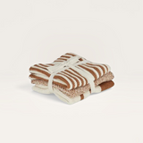 House of Holabox set of three folded knit kitchen cloths in earthy brown and cream striped patterns tied with ribbon