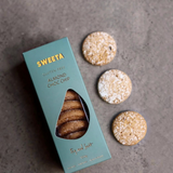 House of Holabox SWEETA gluten-free almond chocolate chip biscuits in a teal box with three cookies on a grey surface.