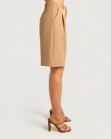 House of Holabox tan high-waisted Bermuda shorts with front pleats and tailored longline fit, side view