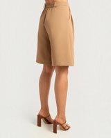 House of Holabox tan high-waisted Bermuda long line shorts with an elasticated back waistband, side view.