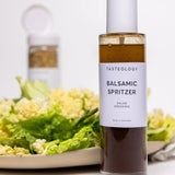 House of Holabox Tasteology balsamic salad dressing in a glass spray bottle served over fresh greens and cauliflower.