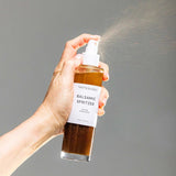 House of Holabox Tasteology balsamic salad dressing in a glass spray bottle being used to spritz dressing