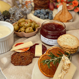 House of Holabox The Peel Thing quince paste served on a grazing board with crackers, cheese, olives, and dried fruit.
