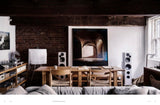 House of Holabox This Is Home book spread showing a rustic living room with brick walls, wooden table, and art.