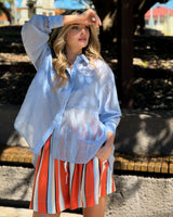 House of Holabox Val oversized pale blue lyocell-blend shirt with a collared neckline worn outdoors.