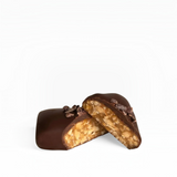 House of Holabox vegan dark chocolate bar cut in half showing a crunchy nut and caramel center with cacao nibs
