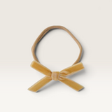 House of Holabox Snuggle Hunny velvet baby headband with a petite mustard yellow bow on a soft stretch nylon band.