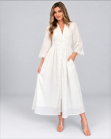 House of Holabox white cotton maxi dress with V-neck, bell sleeves, lace trim, and button-through front on a model.