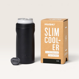 Huski Slim Can Cooler in matte black stainless steel with scalloped sides, silicone base, and included can tab slider next to packaging box.
